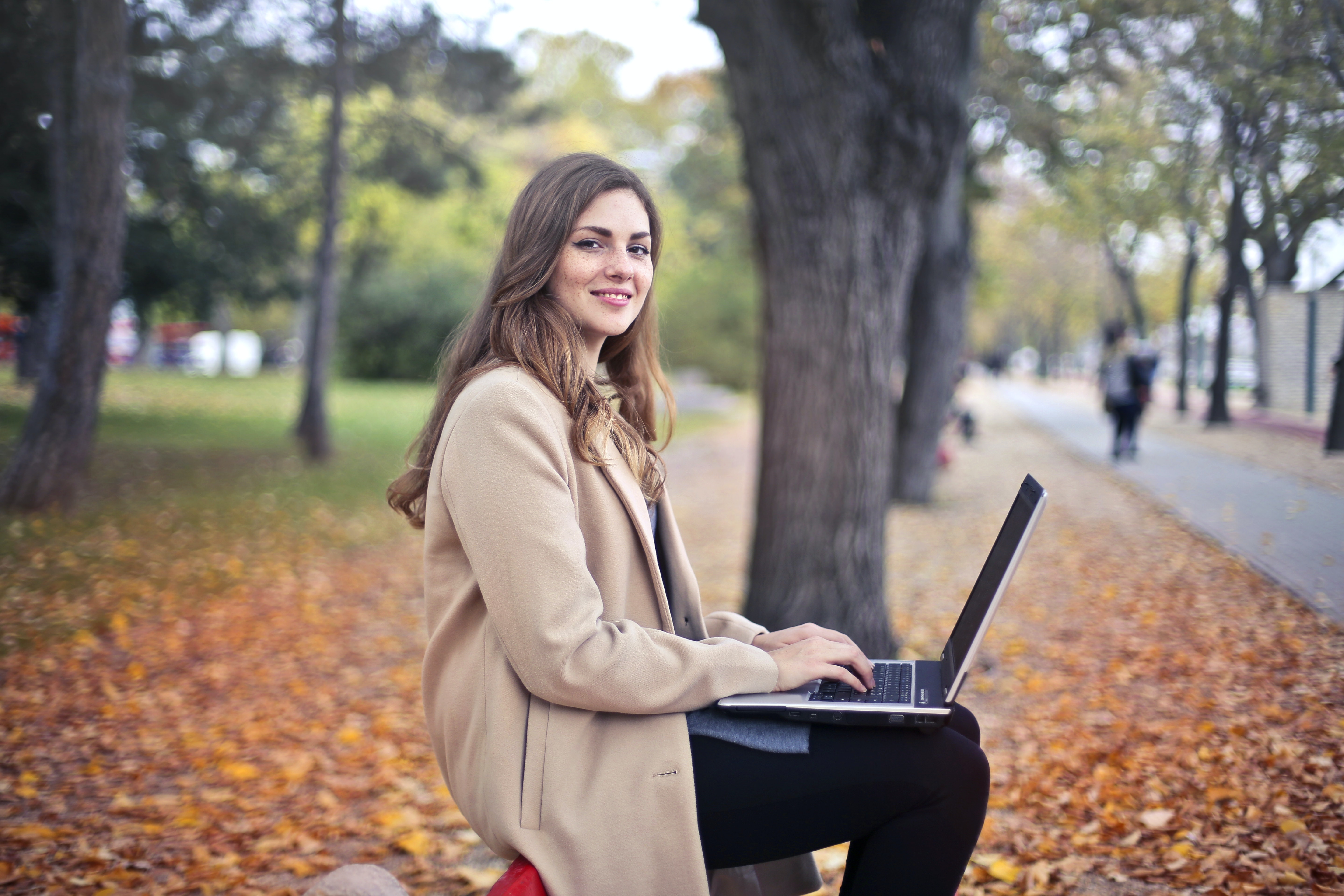 Publisher Newsletter Templates Can Help You With Your Email Marketing Woman sitting on park bench, typing on laptop. Writing your newsletters can be easier with Publisher Newsletter Templates.