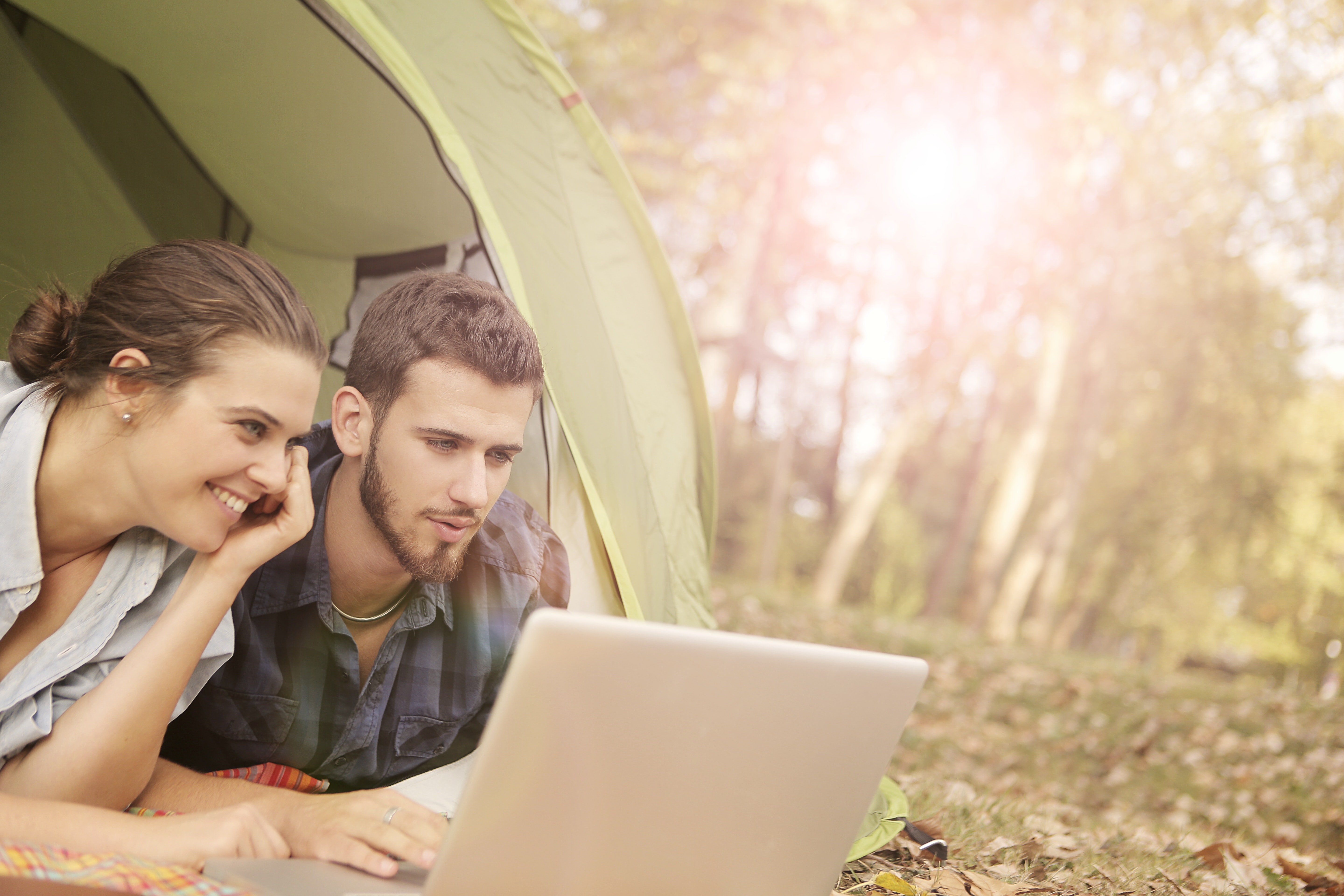 Can You Earn a Living From Anywhere? See This ConvertKit Review to See if it Can Help You Smiling Couple on Computer in Tent