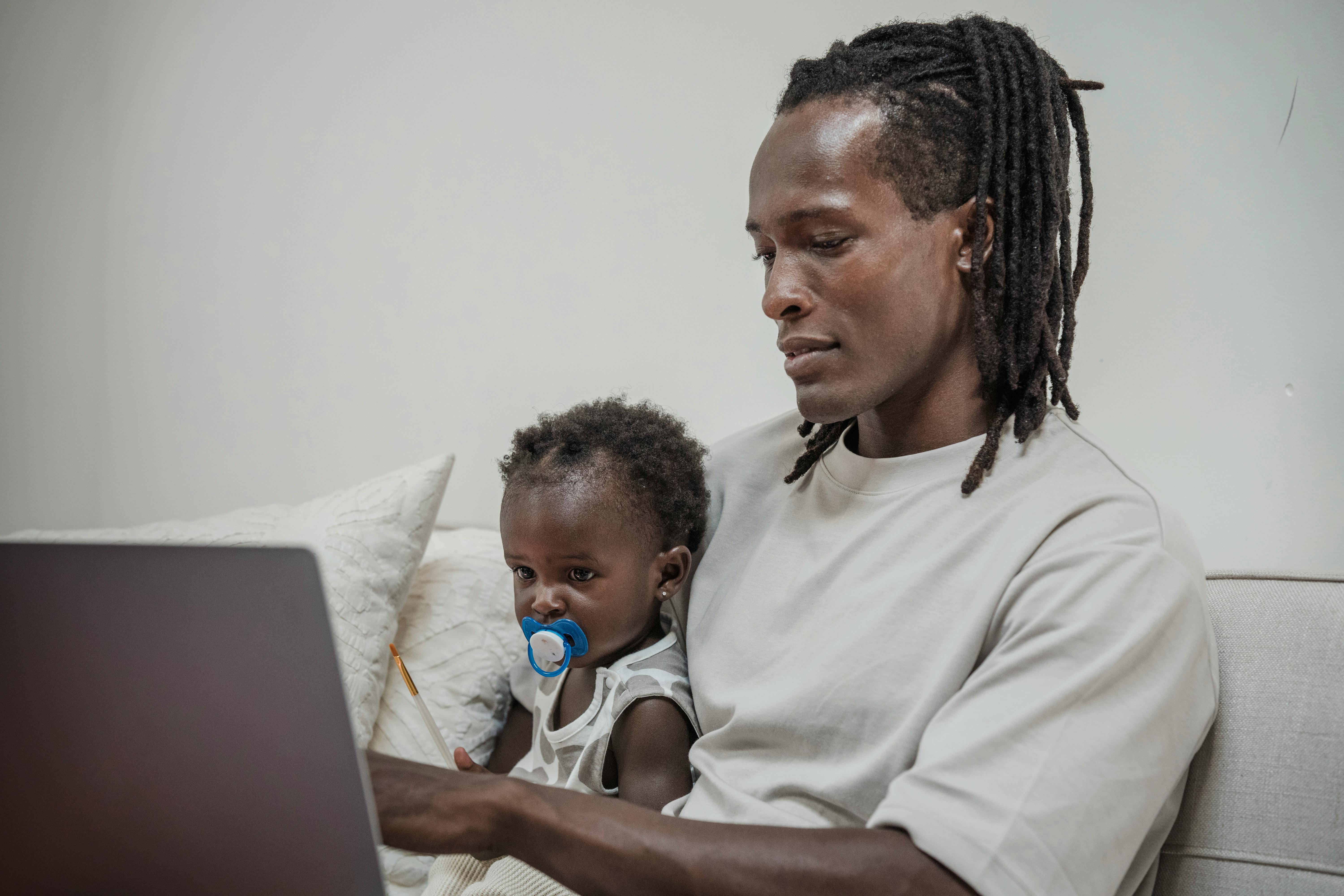 Father with young son on computer. Let's explore how starting to accumulate compound interest at a younger age can be beneficial to growing your wealth.